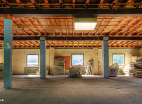 Leere Halle mit freigelegter Decke nach dem Rückbau